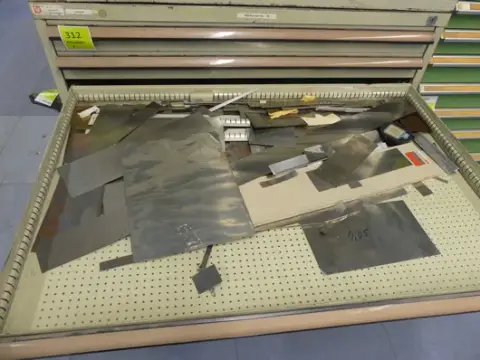Contenu d'armoire : tôles métalliques, découpes, demi-produits, acier rond
