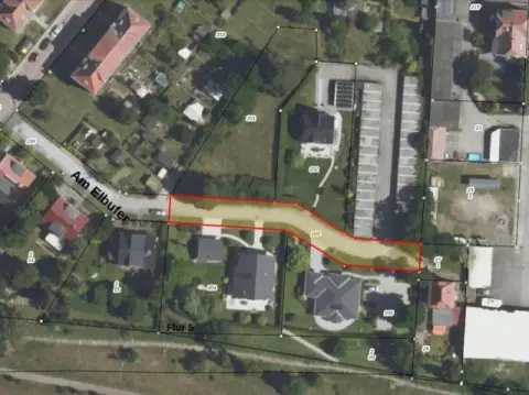 Del af gaden 'Am Elbufer' foran boliger og et garagekompleks i Lutherstadt Wittenberg