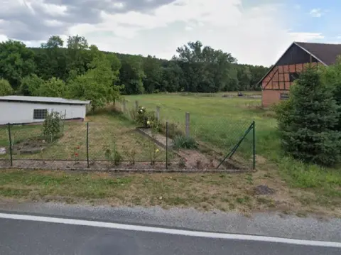 1/4 medejerandel af en grundstrimmel over for boligbebyggelse