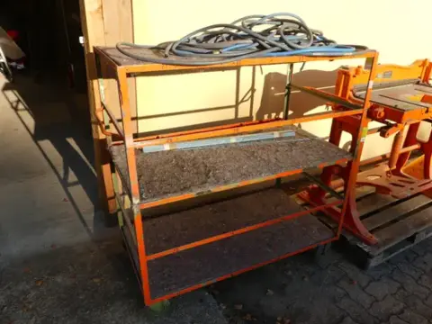 Etagevogn med indhold (trykluftslanger, metalstænger)