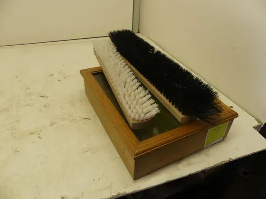 Drvena vitrina sa staklenim poklopcem i četkama