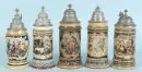 Beer mugs, 5 pieces – ceramic, coloured figure motifs, surrounded by richly relief-decorated ornaments, decorated pewter lids, H= 24-26 cm, around 1900