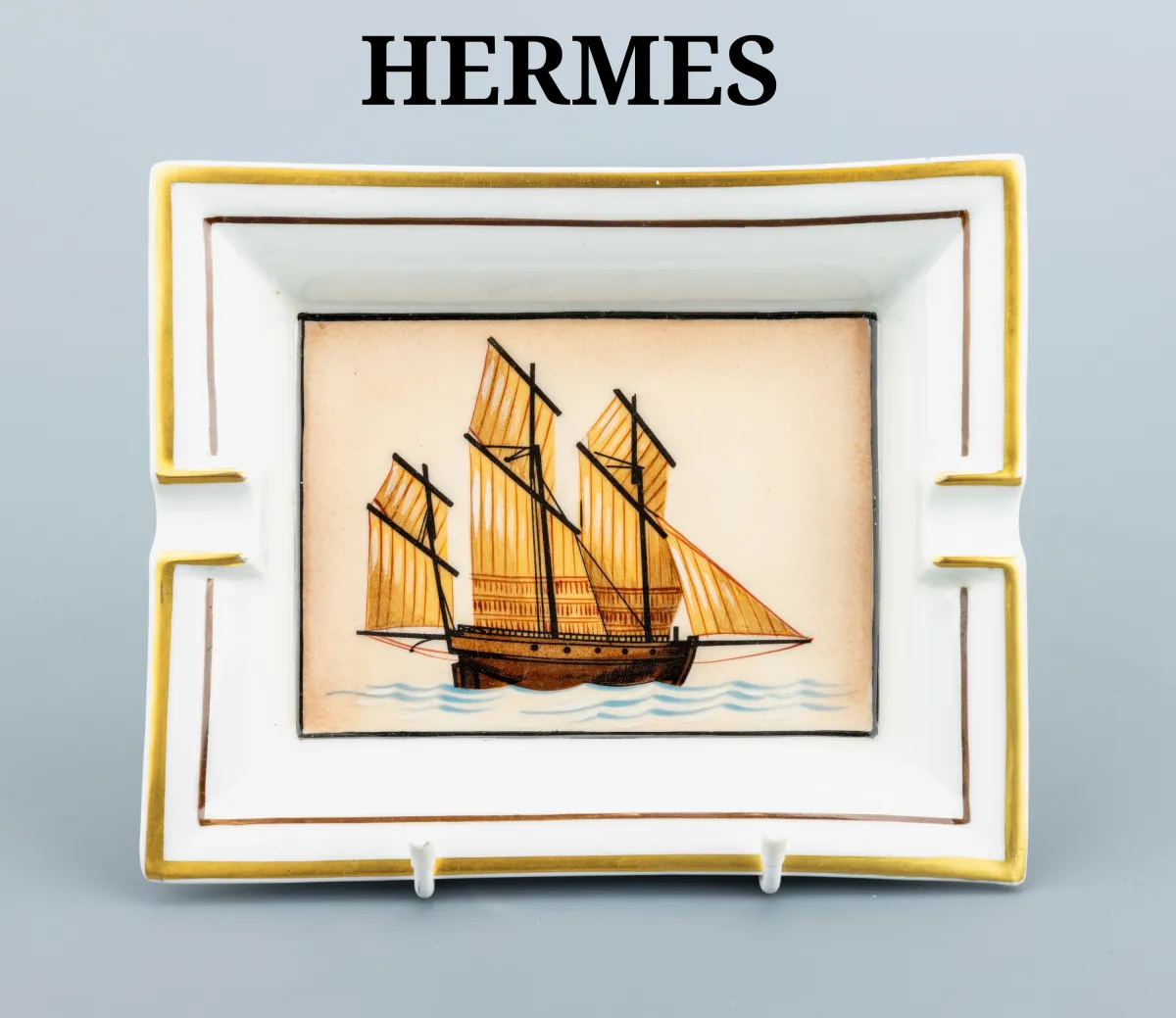 Cendrier HERMES, porcelaine, représentation d'un trois-mâts, brun et doré