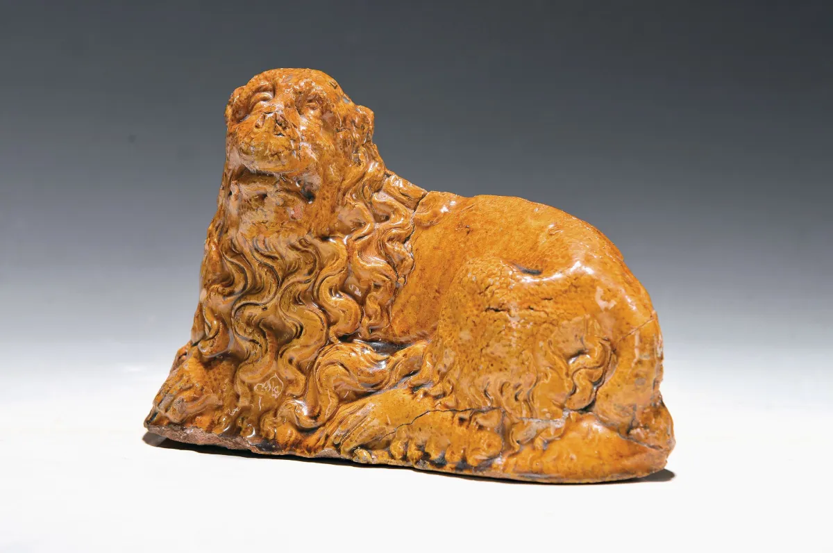 Figurine en grès, probablement 17e s., lion couché à la crinière bouclée, glaçure ocre