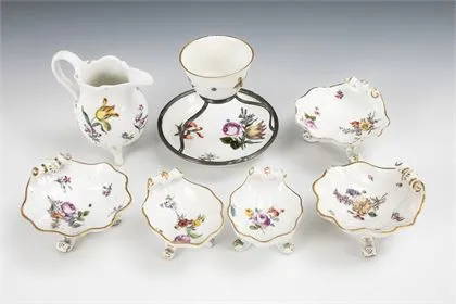 7 baroque porcelains: 5 shell dishes, milk jug and cup with saucer and silver mount. Meissen
