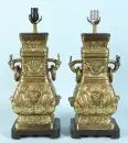 Paire de lampes de table – fonte de laiton, décor en relief, base en bois, corps balustre avec 2 poignées, 1 douille, H= 58 cm