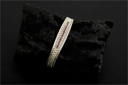 Bracelet en or blanc avec pierres rouges, probablement rubis