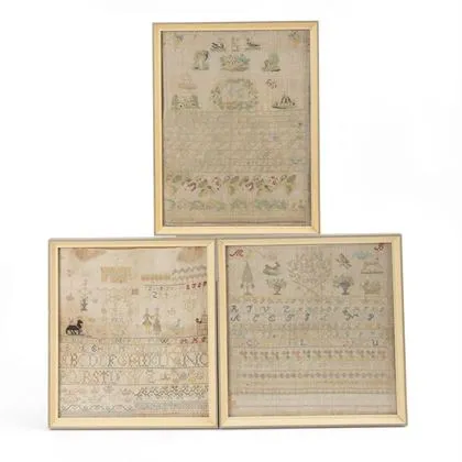 Trois tissus de sampler encadrés