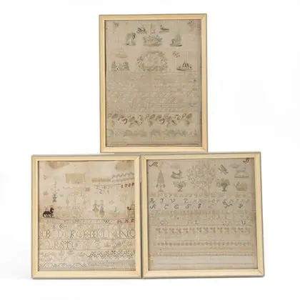 Trois tissus de sampler encadrés
