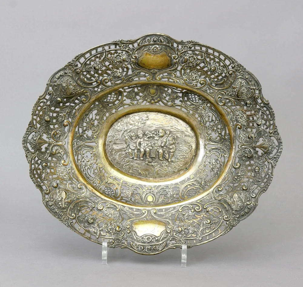 Panier ajouré, argent 800, allemand, probablement Hanau, ovale, avec putti et décor de roses. 33,5 x 28,5 x 6,5 cm. Poids 462 g.