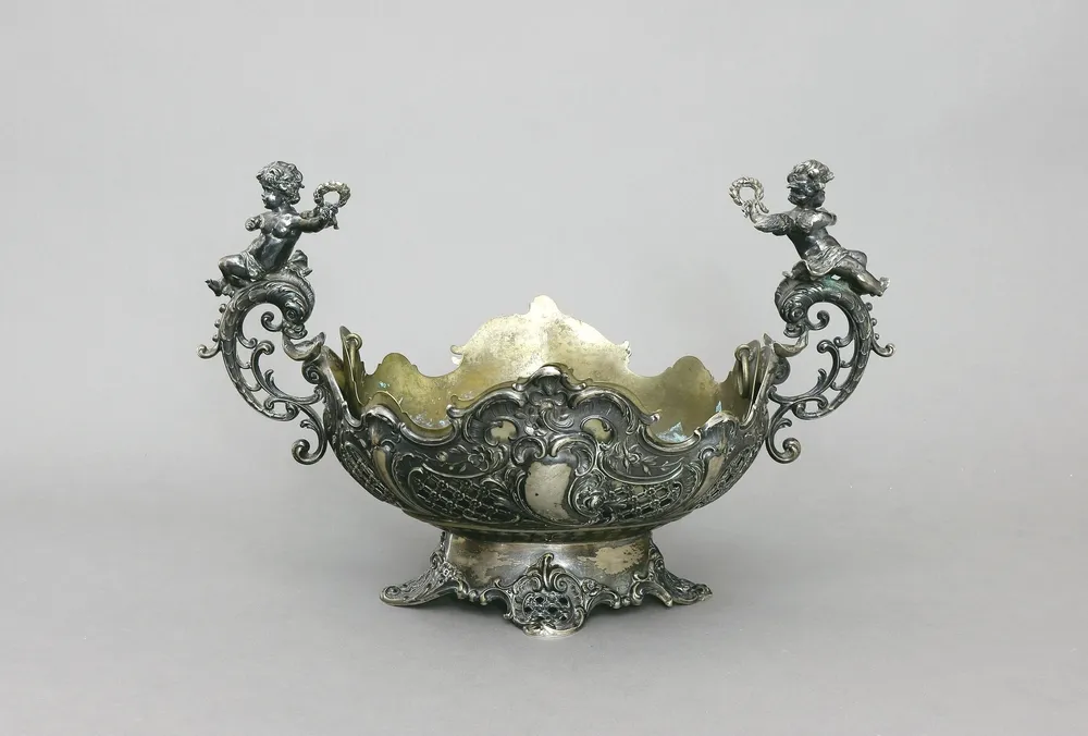 Centerpiece/Jardinière, 800 silver, German, probably Bruckmann & Söhne, Heidelberg, late 19th c. Footed bowl, boat shape, wall with…