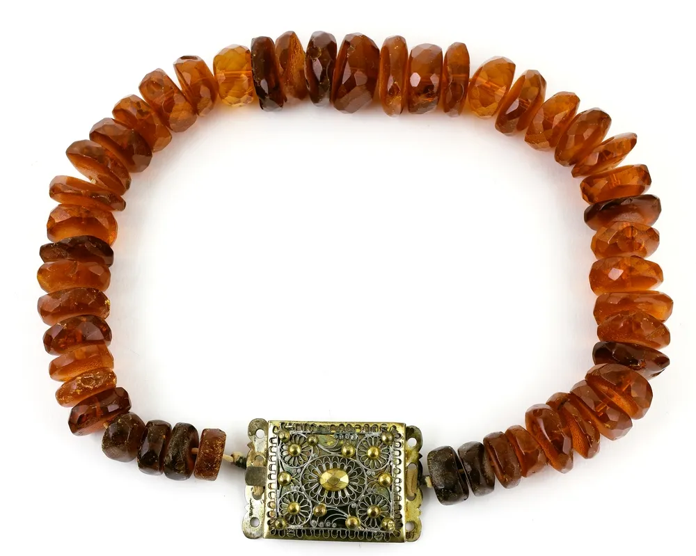 Amber, necklace, antique. 46 medium-sized amber pieces of slightly irregular shape, rectangular brass clasp. Length 70 cm. Weight 303 g.
