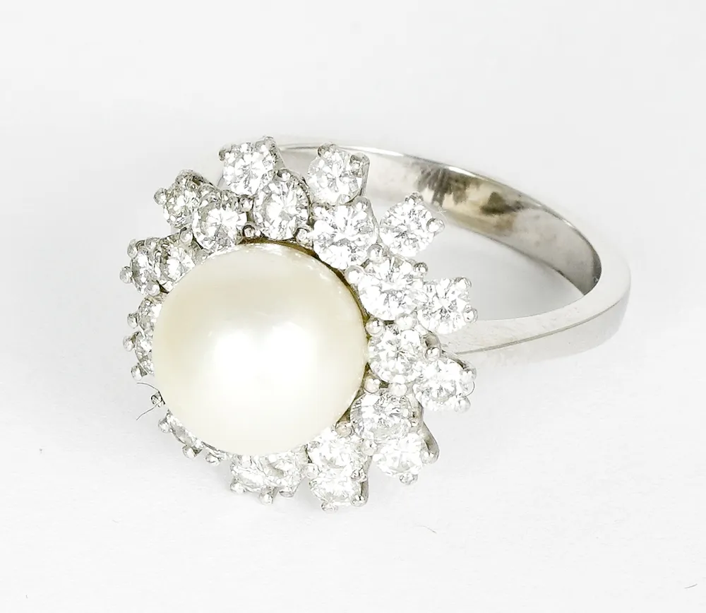 Ring, 750 white gold with large white central pearl D.: approx. 9.5 mm, surrounded by a double circle of 24 small cut diamonds