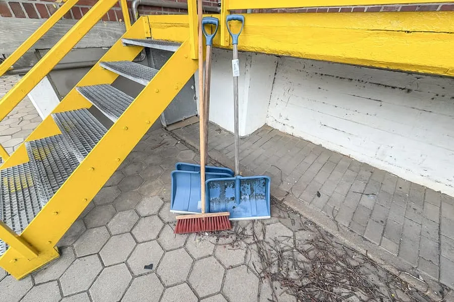 3 sněhové lopaty a košťata